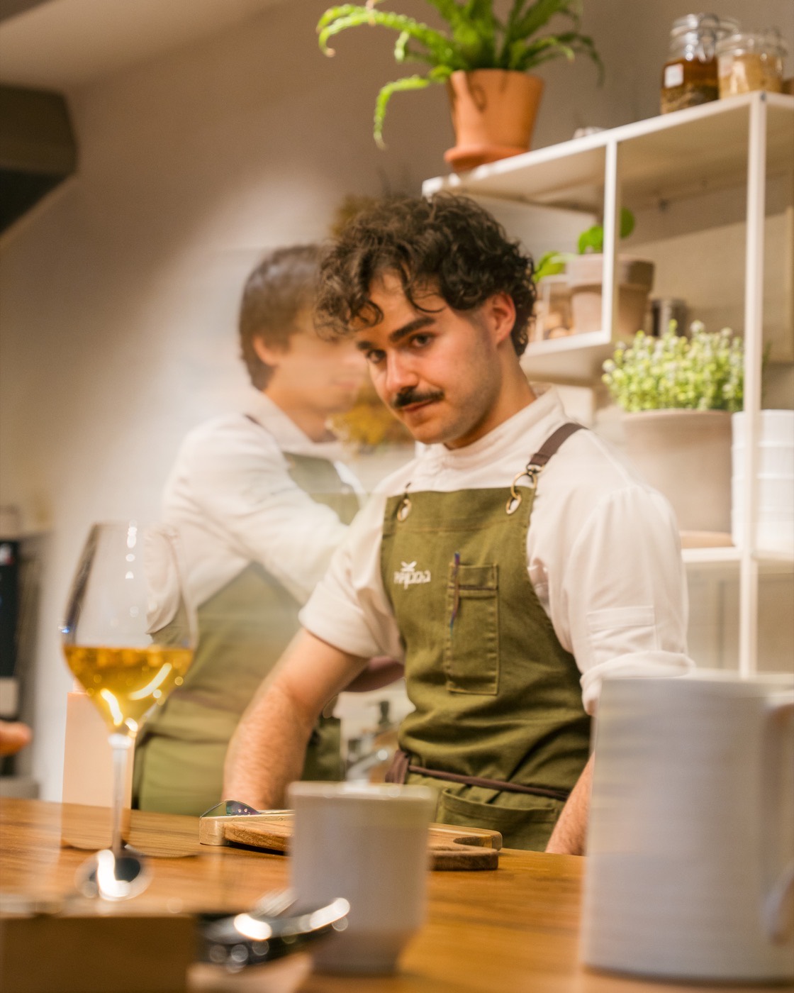 A chef talks with a guest across the counter