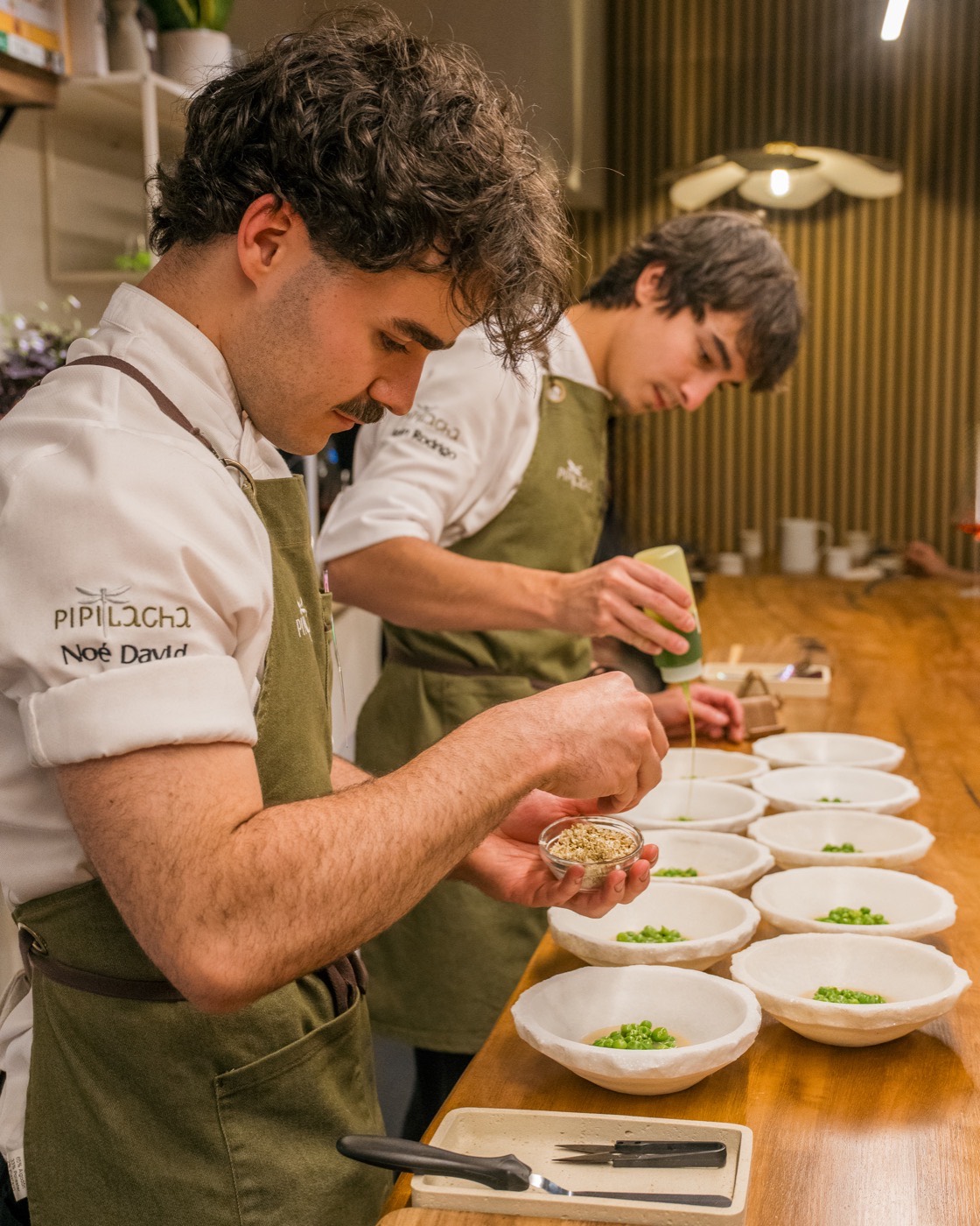 The two chefs plating at the counter during service